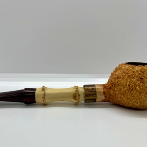 Peut inclure: Une pipe à fumer brune et blanche avec une coupe texturée et une tige brune et blanche.