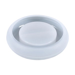 May include: A white, circular mold with a raised, central disc. The mold has a smooth, glossy finish and appears to be made of a durable material. The design is simple and functional, suitable for crafting or other creative projects.
