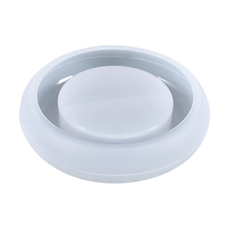 May include: A white, circular mold with a raised, central disc. The mold has a smooth, glossy finish and appears to be made of a durable material. The design is simple and functional, suitable for crafting or other creative projects.