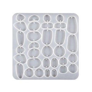 Peut inclure: Un moule en silicone blanc avec 30 formes différentes pour la fabrication de boucles d'oreilles. Le moule présente une variété de formes rondes, ovales et irrégulières.