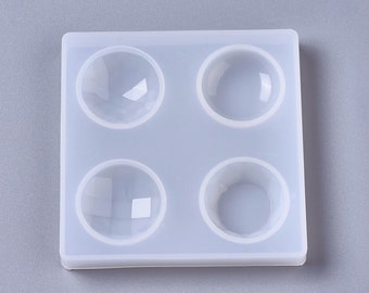 May include: A white silicone mold with four round cavities for making resin crafts. The mold is designed to create dome-shaped resin pieces.