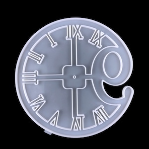 May include: White silicone mold shaped like a clock face with Roman numerals. The mold has a separate section for a clock hand.