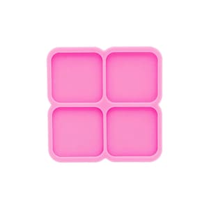 May include: A vivid pink silicone mould featuring four square compartments. The mould has rounded corners, designed for creating small, square objects. The background is plain white, accentuating the bright colour and shape of the mould.