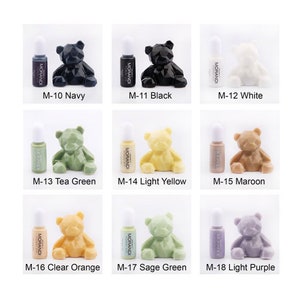 May include: A set of 9 small bottles of paint with a teddy bear figurine in each color. The colors include navy, black, white, tea green, light yellow, maroon, clear orange, sage green, and light purple.