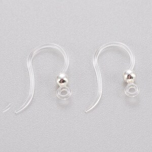 May include: Two clear plastic earring hooks with silver ball ends. The hooks are designed to be used with other jewellery components.