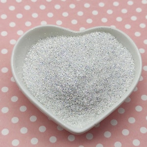 May include: A heart-shaped white bowl filled with iridescent white glitter.