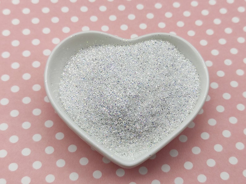 May include: A heart-shaped white bowl filled with iridescent white glitter.