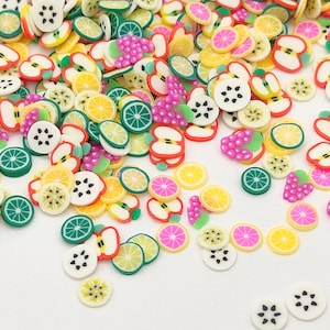 May include: Assortment of colourful fruit-shaped polymer clay charms, including watermelon, apple, lemon, lime, and grape. These charms are perfect for adding a touch of whimsy to jewellery, crafts, and other projects.