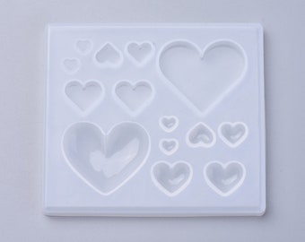 May include: A white silicone mold with 11 heart-shaped cavities of varying sizes. The mold is designed for creating resin crafts.
