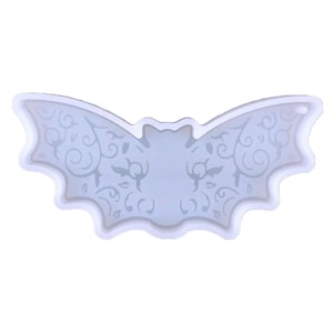 May include: White silicone mould shaped like a bat with a decorative design. The mould is perfect for making resin crafts.