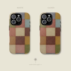 This phone case features a soft, muted checkerboard pattern made up of square blocks in earthy tones—dusty pink, cream, sage green, mustard yellow, brown, and light blue. Each square has a slightly textured, vintage look, creating a warm, cosy, quilt-like aesthetic. No additional graphics or text appear on the case the buyer receives.