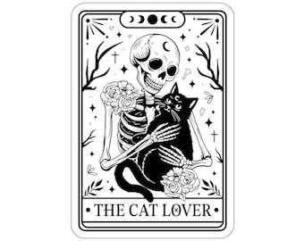 Peut inclure: Illustration en noir et blanc d'un squelette tenant un chat noir. L'image est dans le style d'une carte de tarot et comprend le texte "The Cat Lover".