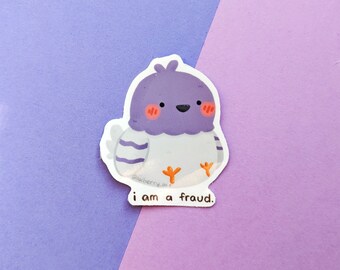 May include: A purple and white cartoon bird sticker with the text "i am a fraud." The bird has a white body with purple wings and a purple head with orange feet. The sticker is on a purple and pink background.