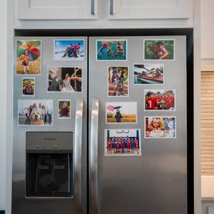May include: A stainless steel refrigerator with a variety of photos attached to it using magnets. The photos are of different sizes and show various people and activities.
