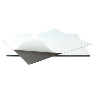 Puede incluir: Dos hojas de papel magn&eacute;tico con respaldo adhesivo. Una hoja es blanca y la otra es negra. La hoja blanca est&aacute; parcialmente despegada para revelar la hoja magn&eacute;tica negra.