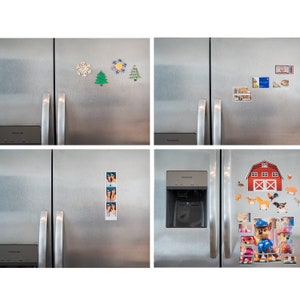 Puede incluir: Cuatro refrigeradores de acero inoxidable con varios imanes adheridos. Los imanes incluyen un copo de nieve, un &aacute;rbol de Navidad, una escena de granja, una tira de fotos y un personaje de dibujos animados.