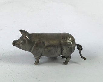 Vent de cochon en plaque d'argent vintage dans un ruban à mesurer à coudre.