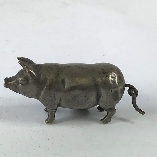 Vent de cochon en plaque d'argent vintage dans un ruban à mesurer à coudre.