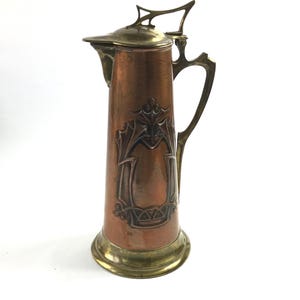 Brocca per vino in rame e ottone in stile Art Nouveau. Circa 1900.