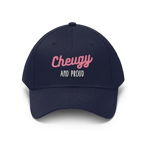 Puede incluir: Una gorra de béisbol azul marino con el texto "Cheugy and Proud" en letras blancas y rosas.
