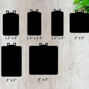 May include: Six black rectangular shapes with rounded corners and two holes at the top. The shapes are different sizes, with measurements in inches listed below each shape. The shapes are on a light wood background.