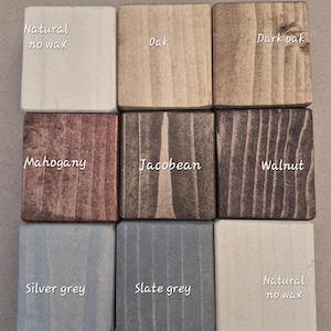 May include: Nine wooden squares showcasing different wood stain colors. Colors include Natural no wax, Oak, Dark oak, Mahogany, Jacobean, Walnut, Silver grey, Slate grey, and Natural no wax. Each square has the color name printed on it.