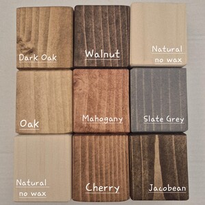 May include: Nine wooden blocks displaying various wood stains. The blocks are labelled with the following colours: Dark Oak, Walnut, Natural (no wax), Oak, Mahogany, Slate Grey, Cherry, and Jacobean. The blocks are arranged in a grid pattern.