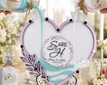 Könnte beinhalten: Ein herzförmiger Sandzeremonie-Rahmen aus Glas mit hellviolettem Rand und dekorativem Blatt-Akzent. In der Mitte befindet sich eine florale Kranzgrafik mit den Initialen S & H, den Namen Steven & Helen und dem Datum 09.20.2025 auf dem Glas.