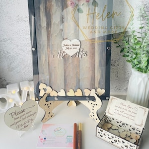 Puede incluir: Un libro de visitas de corazón de madera con un marco negro y un letrero que dice "Por favor, firma un corazón y déjalo caer en el marco para que nunca olvidemos a nuestros seres queridos que vinieron".