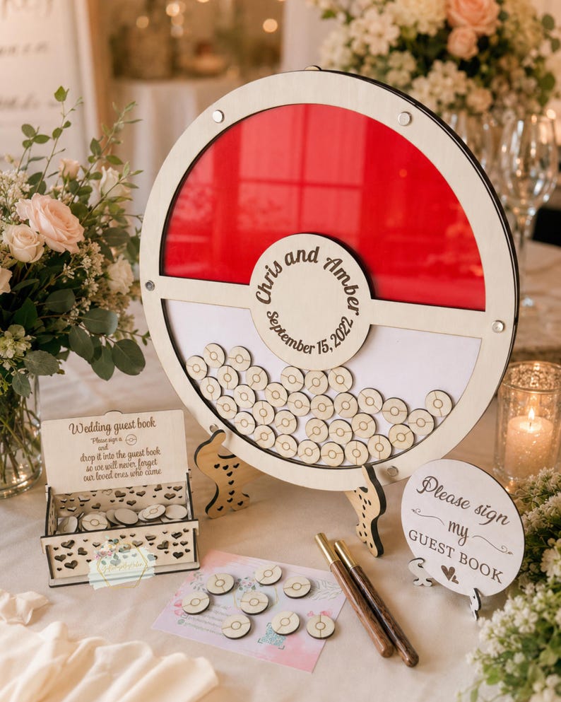 Puede incluir: Un libro de visitas de boda de madera con un dise&ntilde;o circular rojo y blanco. El libro de visitas tiene un marco circular con un fondo rojo y un espacio para que los invitados firmen fichas de madera. Los nombres "Chris y Amber" y la fecha "15 de septiembre de 2022" est&aacute;n grabados.
