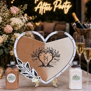 May include: A heart-shaped sand ceremony set with two colours of sand, a decorative frame, and two bottles. The frame has a tree design and the text "Every love story is beautiful, but ours is my favourite." The background includes champagne flutes and a neon sign that says "The After Party."