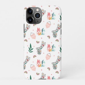 May include: A white phone case with a repeating pattern of pink and blue hearts, rainbows, and the text "Hafa Adai" in a colorful font. The case also features a small outline of the island of Guam.