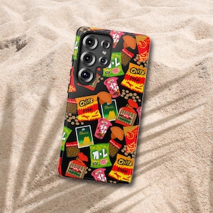 May include: A black smartphone case featuring a colorful pattern of various snack food packages, including bags labeled Chips Pika, Ya Ya cups, and other food illustrations. The case has a cutout for a multi-lens camera system on the back.