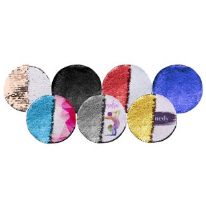 May include: A collection of round, sequined items in various colors, including black, red, blue, gold, and teal. Some items feature a two-tone design, while others have a graphic of a gymnast and the name "Kennedy".