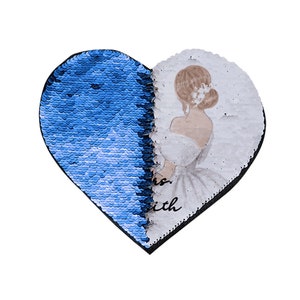 May include: A heart-shaped sequin design, half blue and half with a watercolor illustration of a bride in a white dress. The text "is with" is visible on the bottom left side of the design.