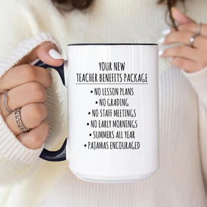 May include: White ceramic mug with a black handle and rim. The mug features the text "YOUR NEW TEACHER BENEFITS PACKAGE" followed by a list of benefits, including "NO LESSON PLANS" and "SUMMERS ALL YEAR".