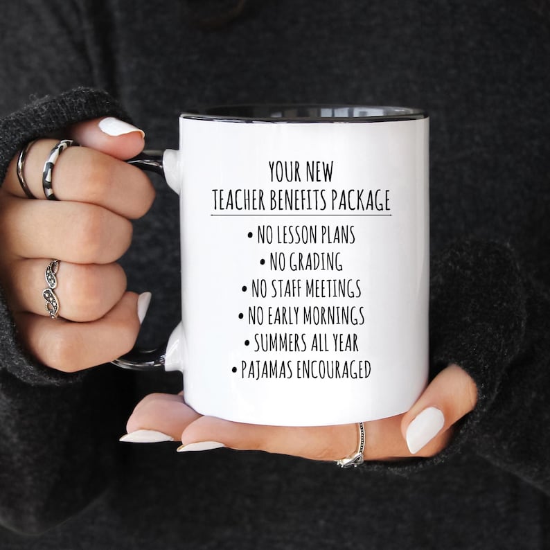 May include: White ceramic mug with a black interior and handle. The mug features the text "YOUR NEW TEACHER BENEFITS PACKAGE" and bullet points listing benefits like "NO LESSON PLANS" and "SUMMERS ALL YEAR".