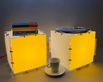 Par de cubos de luz de colores de diseño ecológico que combinan diseño minimalista y durabilidad. Se pueden usar como lámpara de mesa o colgante.