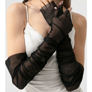 May include: Black sheer long gloves with a gathered detail. The gloves are fingerless and extend to the elbow.
