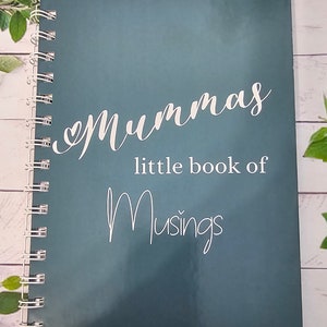 Op de afbeelding: Een tealblauw spiraalgebonden notitieboek met de tekst "Mummy's little book of Musings" in witte letters.