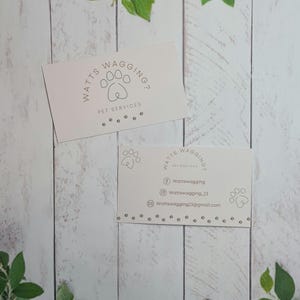 May include: Two white business cards with the text "Watts Wagging? Pet Services" and contact information. The cards feature a paw print design.