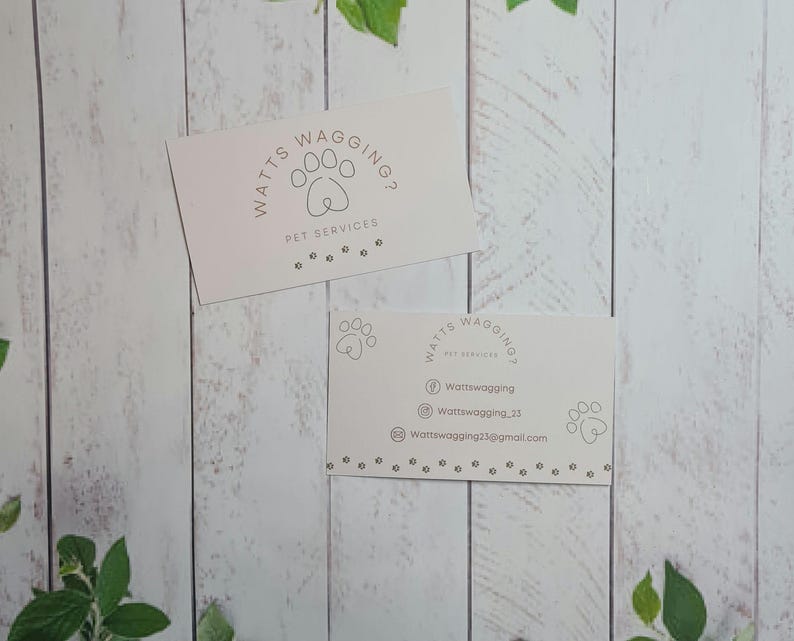 May include: Two white business cards with the text "Watts Wagging? Pet Services" and contact information. The cards feature a paw print design.