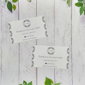 May include: Two white thank you cards with black text and decorative borders. The text on the cards reads "Thank you for your order. Please Snap, Tag & Share. Mom's Macrame. Based in Carrick On Shannon."