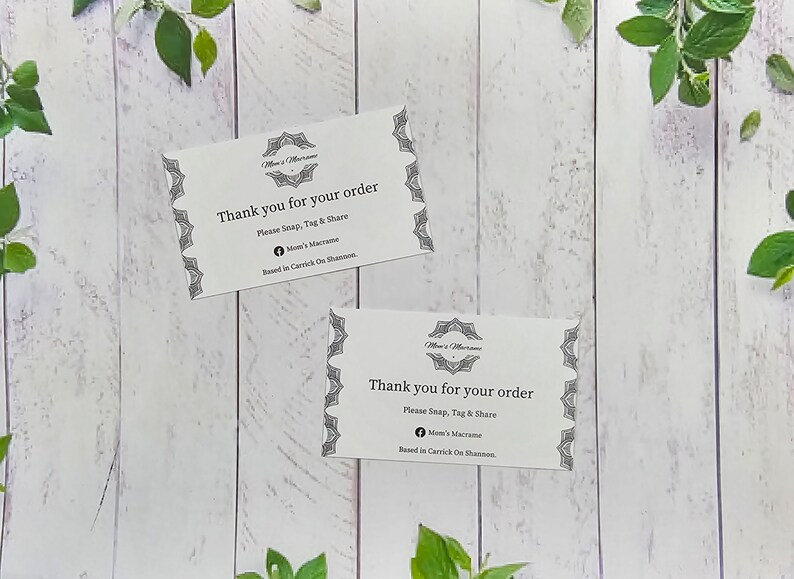 May include: Two white thank you cards with black text and decorative borders. The text on the cards reads "Thank you for your order. Please Snap, Tag & Share. Mom's Macrame. Based in Carrick On Shannon."