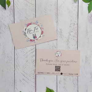May include: Two pink business cards with a floral design. The top card has the text "Tip-Toe Beauty" and a logo of two nail polish bottles. The bottom card says "Thank you for your purchase. Please snap, tag & share!" and has a QR code.