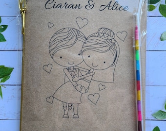 May include: A brown card with a black and white illustration of a bride and groom holding each other. The card says "The Wedding of Ciaran & Alice" and "2nd July 2022". A rainbow colored pencil is included.