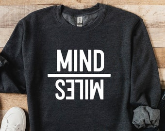 May include: A dark gray sweatshirt with the text "MIND OVER MILES" printed in white on the front.