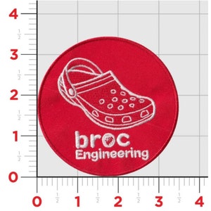 K&ouml;nnte beinhalten: Runder, gestickter Aufn&auml;her in Rot mit einer wei&szlig;en Umrandung eines Clogs und dem Text "broc Engineering".