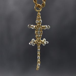 May include: A gold and silver lizard pendant necklace. The lizard is made of small, round beads and has a long tail.