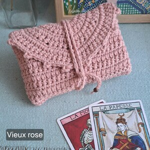May include: A dusky pink crochet pouch with a flap and drawstring closure. Two tarot cards are next to the pouch, one with a skeleton and the other with a crowned woman. The image includes the text "Vieux rose".
